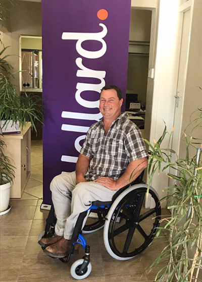 Alfie smiling, sitting in his brand new wheelchair from Hollard