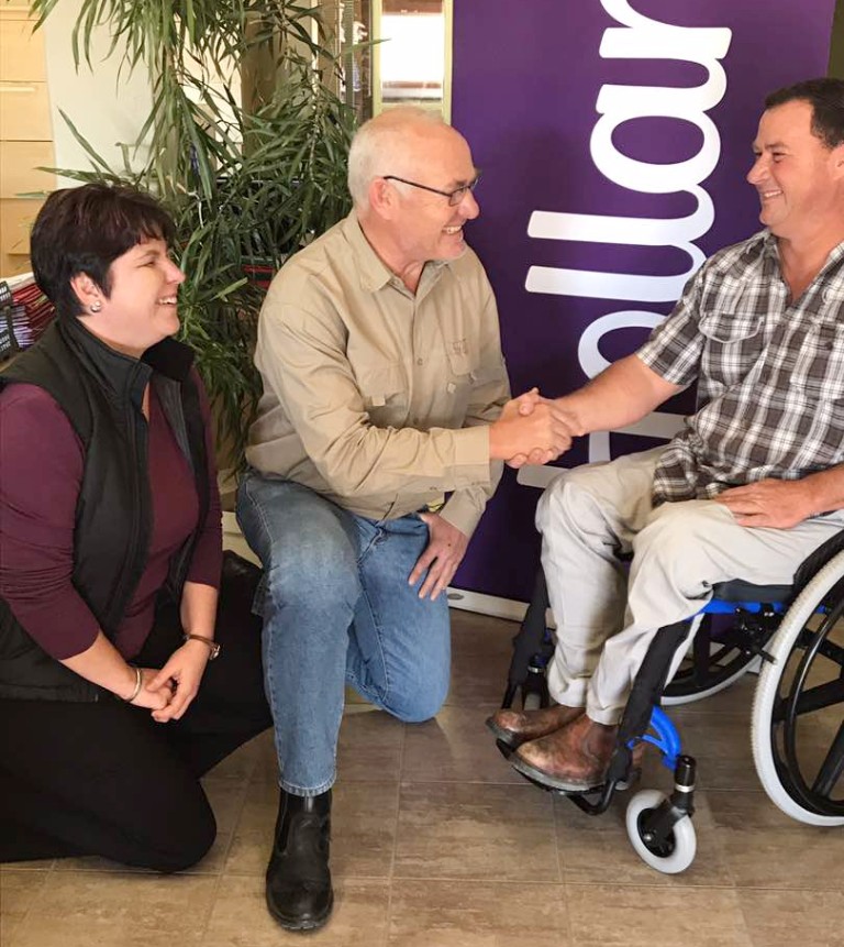 Alfie Truter in a wheelchair, shaking hands with a man, laughing